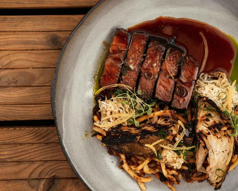 Foto eines Fleischgerichts mit Sauce und Beilagen