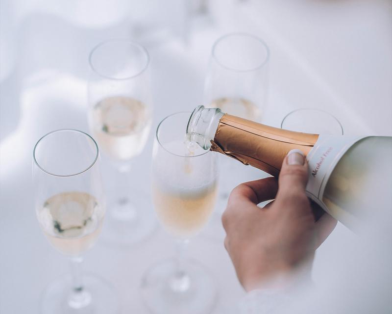 Bild eines Tabletts mit Sektgläsern, die gerade eingeschenkt werde